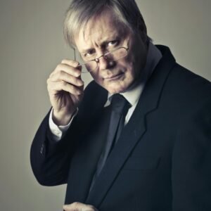 Serious senior adult man with glasses in a suit, conveying professionalism in a portrait shot.